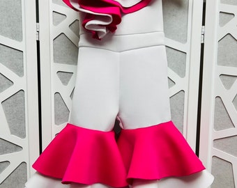 May include: White and pink ruffled one-piece outfit with a single ruffle on the shoulder.