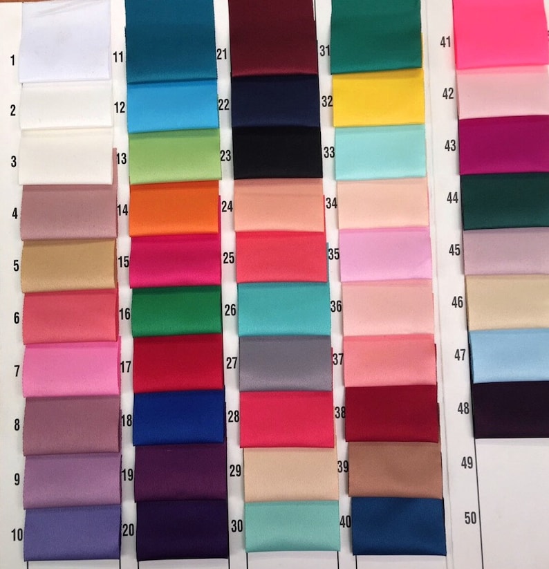 May include: A color chart displaying a variety of satin ribbon swatches. The swatches are arranged in rows and columns, showcasing a spectrum of colors including white, teal, pink, and purple. Each swatch is labeled with a number from 1 to 50.