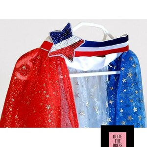 May include: Red, white, and blue cape with gold glitter stars. The cape has a white collar with a red, white, and blue ribbon and a sequined star.