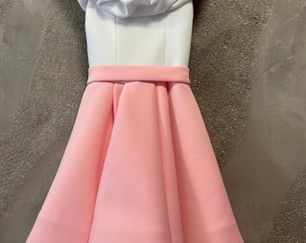 May include: A white and pink dress with a ruffled neckline and a full skirt.