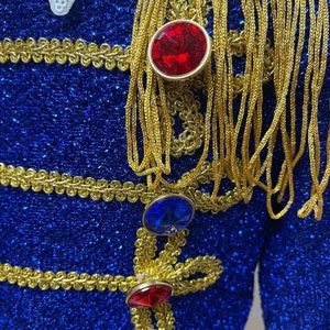 May include: A blue sequined jacket with gold trim and red and blue jeweled buttons.