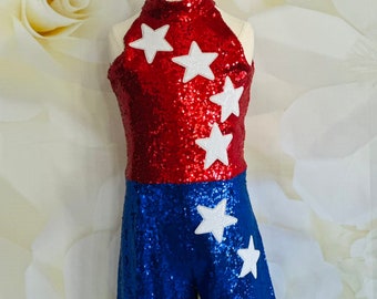 May include: A red and blue sequined leotard with white star appliques. The leotard has a halter neckline and a short skirt.