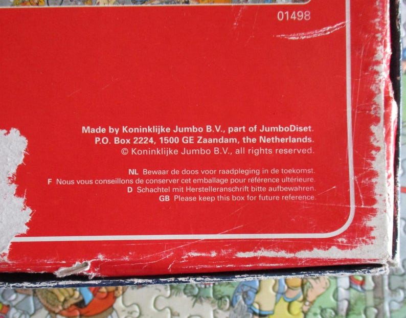 May include: A red cardboard box with white text reading Made by Koninklijke Jumbo B.V., part of JumboDiset. P.O. Box 2224, 1500 GE Zaandam, the Netherlands. &copy; Koninklijke Jumbo B.V., all rights reserved. The box shows signs of wear and scuffing.