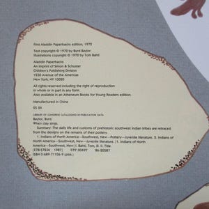 May include: A book cover with a light blue background and a brown outline. The title is "When Clay Sings" by Byrd Baylor. The book is about the daily life and customs of prehistoric southwest Indian tribes. The book is part of the Aladdin Paperbacks series.