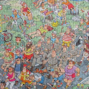 May include: A colorful jigsaw puzzle featuring a crowded outdoor scene with numerous cartoon characters in various outfits, including hikers, cyclists, and people relaxing on grass, with a yellow signpost and a red bicycle visible on the left.