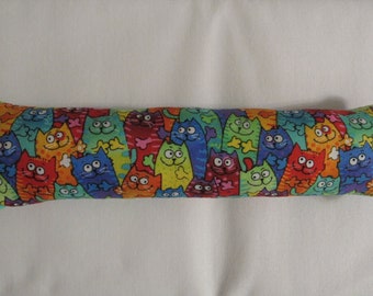 May include: A long, rectangular cat-shaped pillow with a colorful print of many cats. The cats are all different colors and have different expressions.