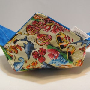May include: A blue and white fabric bowl with a sea life print. The bowl is folded and has a label that says "Jersey Girl Creations".