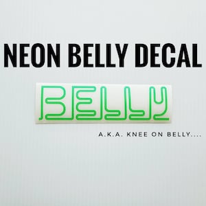 May include: Neon green vinyl decal with the word "BELLY" written in a stylized font. The text "A.K.A. KNEE ON BELLY..." is written below the decal.