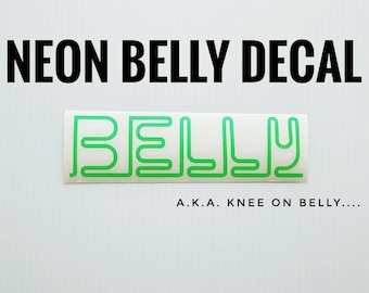 May include: Neon green vinyl decal with the word "BELLY" written in a stylized font. The text "A.K.A. KNEE ON BELLY..." is written below the decal.