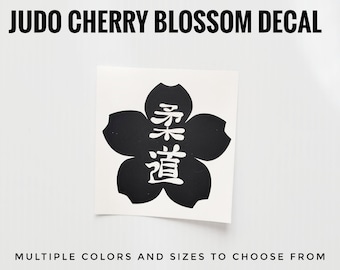 May include: Black and white decal of a cherry blossom with the Japanese characters for "Judo Way" in white.