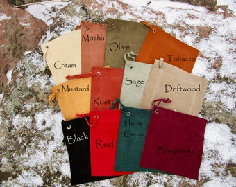 May include: A set of 12 small drawstring bags in various colors, including cream, mustard, mocha, olive, tobacco, driftwood, sage, rust, black, red, hunter green, and burgundy. Each bag has a label with its color name.