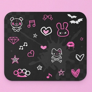 May include: Black and pink mousepad with a variety of cute and edgy graphics, including a bear, a heart, a diamond, a music note, a bow, a bat, a skull, and a kiss mark.