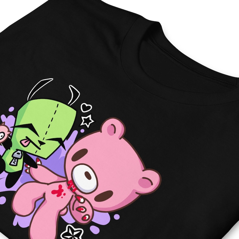 Puede incluir: Camiseta negra con un gr&aacute;fico de dibujos animados rosa y verde de un oso y una criatura con una boca de cremallera. El oso sostiene un cuchillo ensangrentado y la criatura se lame los labios.
