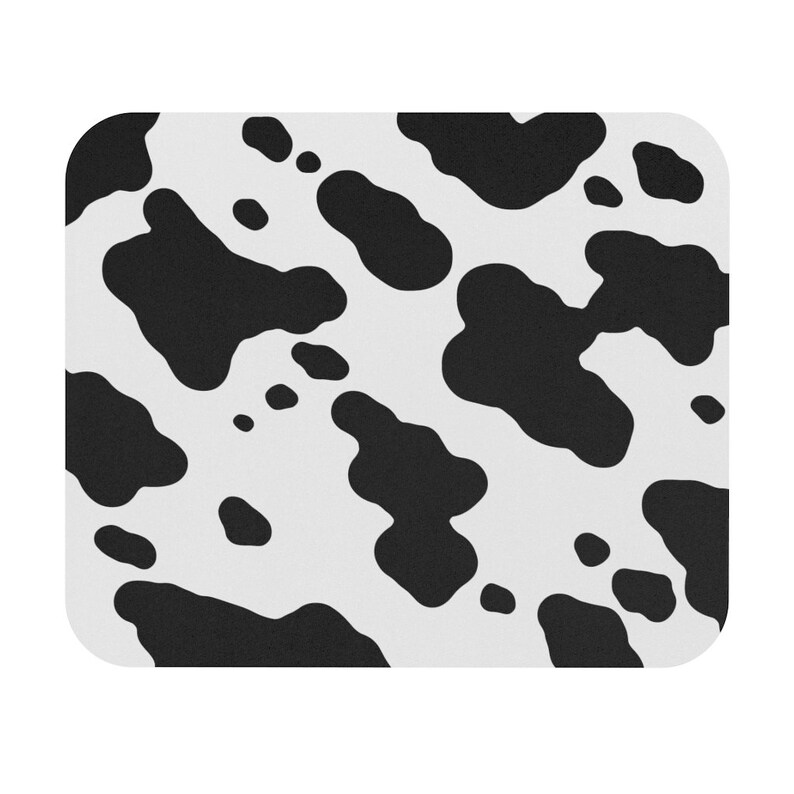May include: Black and white cow print mouse pad. The mouse pad has a white background with black spots of various sizes and shapes.
