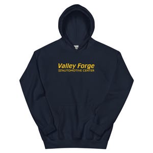 May include: Navy blue hooded sweatshirt with the text "Valley Forge Automotive Center" in yellow.