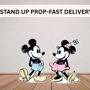 Puede incluir: Cartel de Mickey Mouse y Minnie Mouse. Mickey lleva pantalones cortos azules y zapatos amarillos. Minnie lleva una falda rosa y zapatos amarillos. El texto "STAND UP PROP-FAST DELIVERY" est&aacute; en la parte superior.
