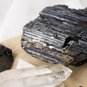 May include: Black tourmaline crystals, also known as schorl, are a type of gemstone that is believed to have protective and grounding properties. These crystals are often used in healing and meditation practices.