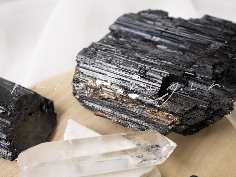 May include: Black tourmaline crystals, also known as schorl, are a type of gemstone that is believed to have protective and grounding properties. These crystals are often used in healing and meditation practices.