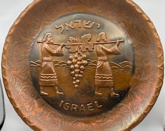 Plato antiguo israelí de cobre repujado con motivo de viñadoras.