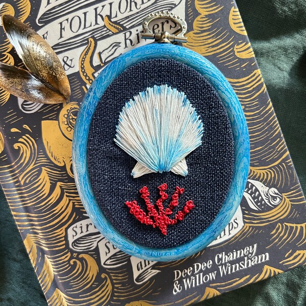 Sea shell embroidery on linen with coral branch.