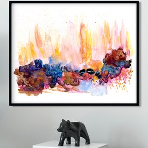 May include: Abstract watercolor painting in a black frame with a colorful, layered design of pink, orange, yellow, blue, and purple hues. The painting has a white background.