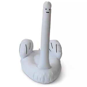 Pode incluir: Um flutuador inflável branco em forma de cisne com um pescoço longo e ereto. O cisne apresenta um rosto minimalista com dois pontos pretos para os olhos e uma linha preta horizontal para a boca. Duas asas arredondadas com detalhes em linhas pretas.