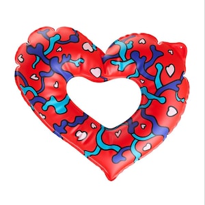 May include: An inflatable heart-shaped pool float featuring a vibrant red base color. The surface is decorated with an abstract pattern of interconnected dark blue and light blue organic shapes, interspersed with small, scattered white heart icons.