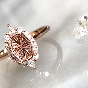 May include: A rose gold ring setting with a pave diamond halo and a pear-shaped center stone setting. The ring is shown next to a loose pear-shaped diamond.