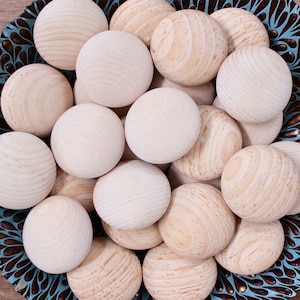 May include: A blue and brown patterned bowl filled with smooth, round, wooden balls.