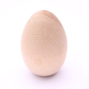 May include: A smooth, light brown wooden egg. The egg is a simple, oval shape and has a natural wood grain.