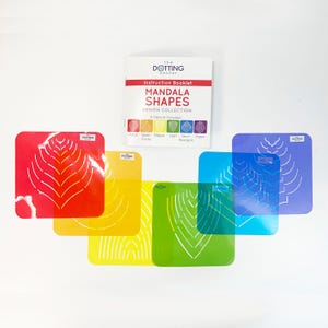 May include: A set of six colourful plastic stencils for creating mandala shapes. The stencils are arranged in a rainbow pattern, with red, orange, yellow, green, blue, and purple. The stencils are labelled with the names of the shapes they create, including "petal", "semi-circle", "ellipse", "leaf", "semi-hexagon", and "ogée".