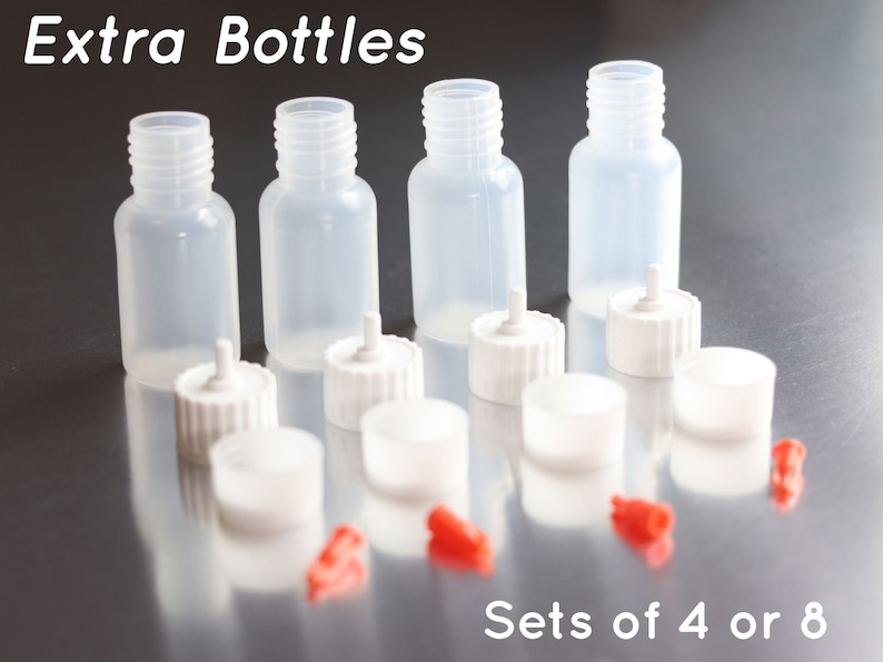 May include: Set of four clear plastic bottles with white dropper caps. The bottles are labeled "Extra Bottles" and "Sets of 4 or 8".