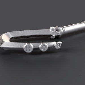 May include: A silver-colored metal hook with a handle and four buttons that spell out "HOG".