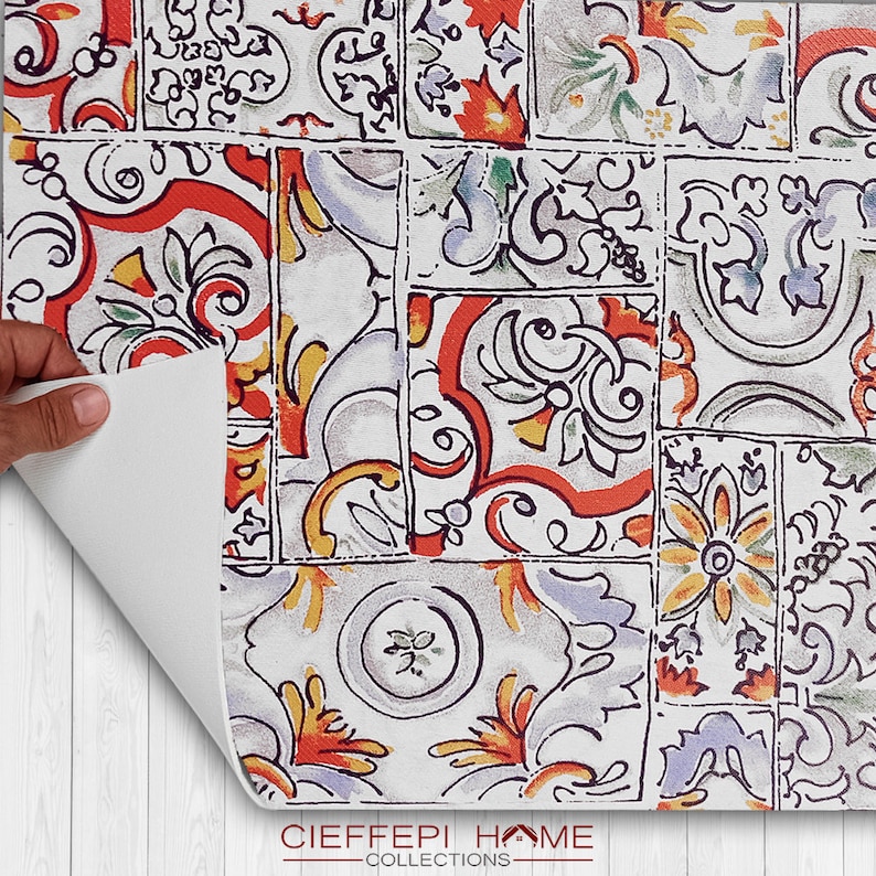 May include: A white background with a colorful patterned design. The pattern is made up of various shapes and colors, including red, orange, yellow, green, blue, and purple. The pattern is reminiscent of traditional tile designs.