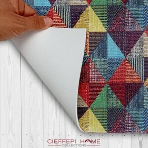 May include: A colorful geometric patterned rug with a white backing. The rug is made of a soft, durable material and is perfect for adding a touch of style to any room.