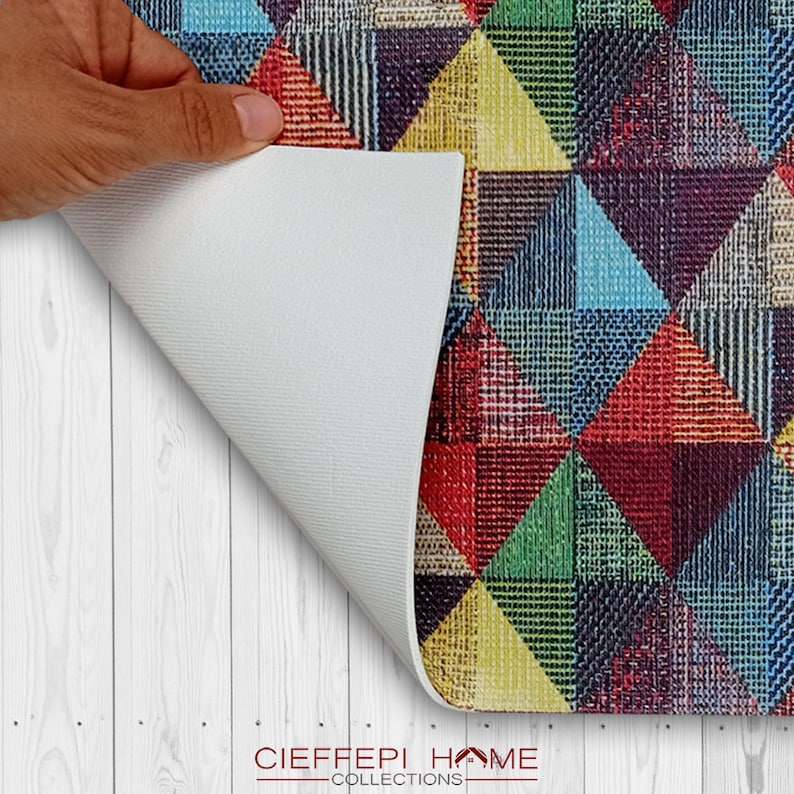 May include: A colorful geometric patterned rug with a white backing. The rug is made of a soft, durable material and is perfect for adding a touch of style to any room.
