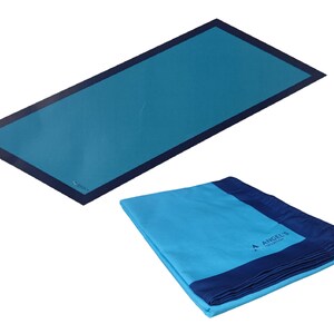 Può includere: Un asciugamano da spiaggia blu piegato con un bordo blu scuro e il testo "Angel's Collection" ricamato sull'asciugamano.