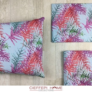 Puede incluir: Un juego de ropa de cama azul y blanca con un estampado floral rosa y rojo. La ropa de cama incluye una funda de almohada y una sábana plana. El estampado presenta hojas de helecho con un efecto acuarela.