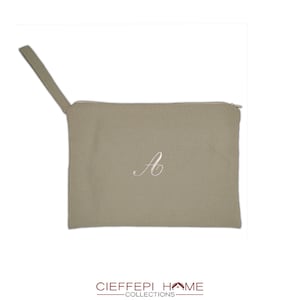 Può includere: Una pochette beige in tela con cerniera, con una lettera "A" ricamata in bianco e un manico in pelle marrone.