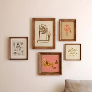 Op de afbeelding: Een galeriewand met vijf ingelijste prints. De prints tonen een woestijnlandschap met een bord waarop staat "Relax! Take it Easy", een vrouw in een cowboyhoed, een verzameling cactussen, een man in een geprint pak en een gouden inscriptie die zegt "Good luck babe!"