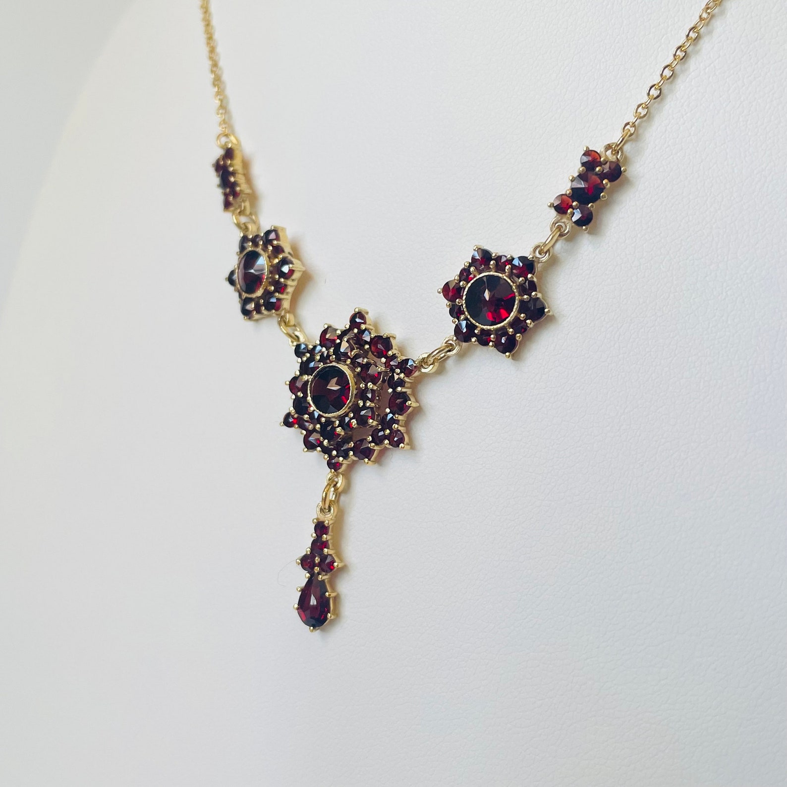 Bohemian garnet drop necklace with gold vermeil, featuring red gemstone cluster in close-up angled view.