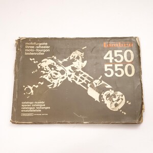 K&ouml;nnte beinhalten: Ein braunes und wei&szlig;es Vintage-Buch mit dem Titel "Lambra 450 550" und dem Text "motofurgone three-wheeler moto-fourgon lastenroller catalogo ricambi spares catalogue catalogue rechanges ersatzteileliste INNOCENTI DIVISIONE MOTORI".