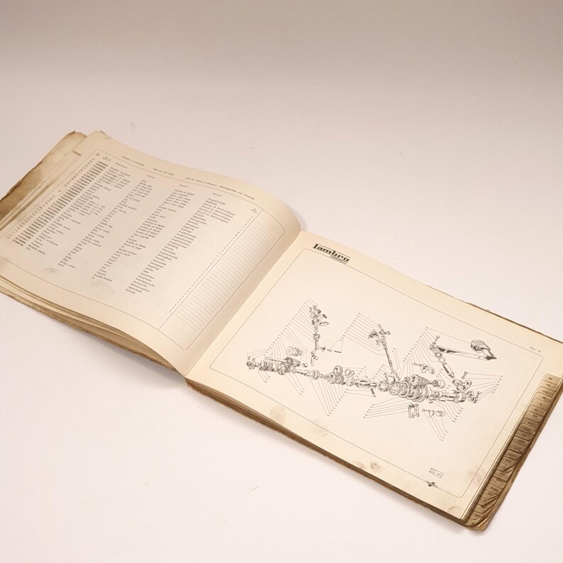K&ouml;nnte beinhalten: Ein offenes Buch mit einem Schwarzwei&szlig;diagramm eines Traktorteils. Das Buch tr&auml;gt den Titel "Lambro" und enth&auml;lt auf der linken Seite eine Liste von Teilen und Nummern.