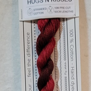 May include: A skein of red and burgundy stranded cotton embroidery thread, labelled "Hugs N Kisses." The label includes the number 1007, and details about the cotton, including 10m pre-cut lengths of 50cm. The thread is hand-dyed in Australia.
