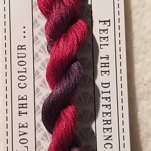 May include: A skein of Waratah stranded cotton embroidery floss. The thread is a blend of red and purple, with the label reading "Love the Colour" and "Feel the Difference". The label also indicates the thread is 10 meters pre-cut.