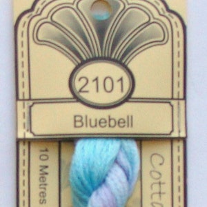 May include: A skein of blue and purple embroidery floss labeled "2101 Bluebell" and "Cottage Craft 10 Metres - Pre-Cut"