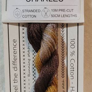 May include: Stranded cotton embroidery floss in shades of brown, gold, and tan. The label reads "No. 1803 CHARLES" and includes details about the 10M pre-cut, 50cm lengths. The floss is hand-dyed in Australia.