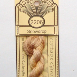 May include: A skein of "Snowdrop" colored embroidery floss, with a light brown and cream color gradient. The floss is 100% cotton and comes in pre-cut lengths. The label reads "Cottage Garden Threads" and has the number "2206".