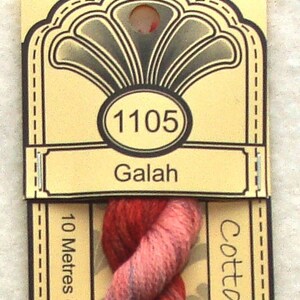 May include: A skein of red, pink, and blue yarn labeled "1105 Galah" with "Cottage" and "10 Metres - Pre-Cut" text on the packaging.
