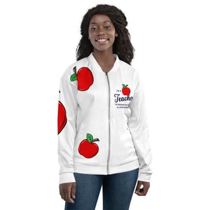 May include: White bomber jacket featuring red apple graphics and the text "I'm a Teacher". The jacket has a zipper closure and is worn by a person. The text also reads "The profession that creates all other professions."